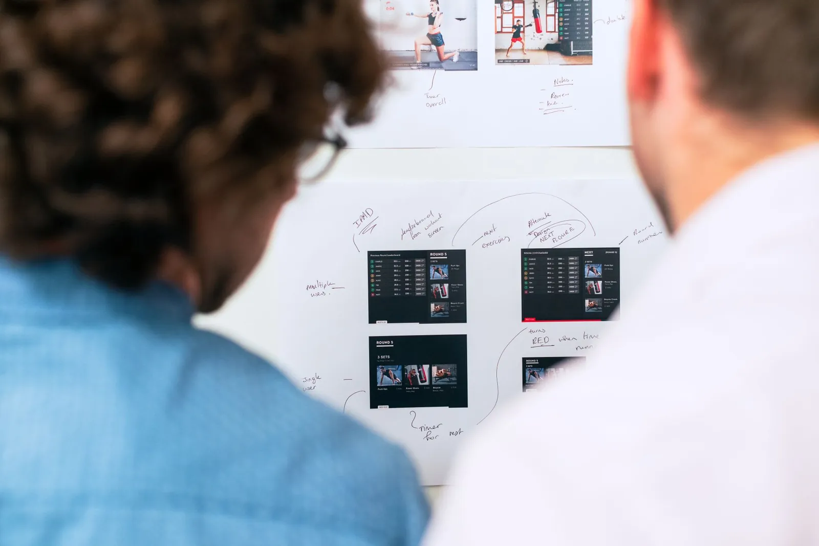 Two business professionals brainstorming and planning software development with a whiteboard in an office. Stock photo illustrating HCL Technologies' product launched story.