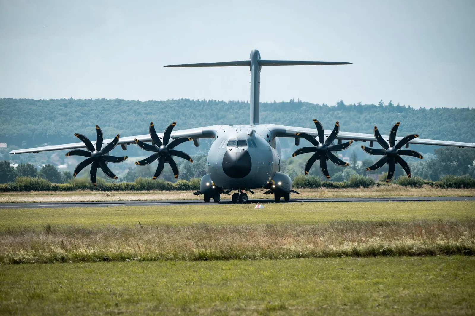 Front view of a military A400M aircraft on the runway against a forest backdrop. Stock photo illustrating Afcom Holdings' fund raise story.