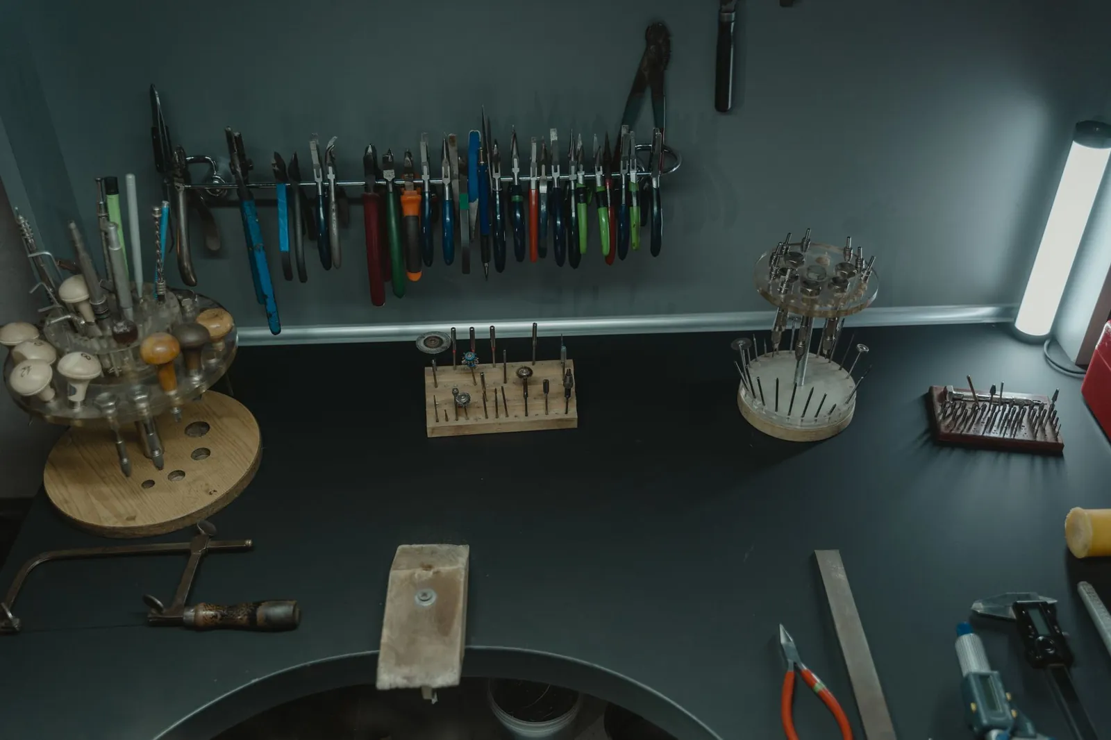 A well-organized jeweler's workstation with various tools, pliers, and accessories displayed neatly. Stock photo illustrating Ashapuri Gold Ornament's new order story.