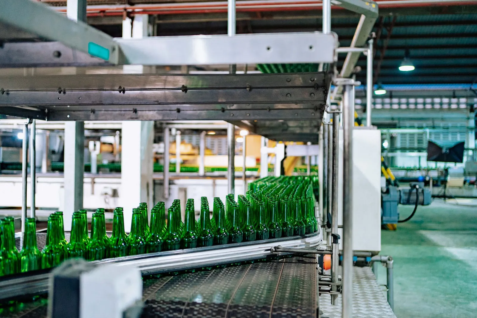 Streamlined glass bottle manufacturing process in factory setting, showcasing assembly line automation. Stock photo illustrating Borosil Renewables' expansion story.