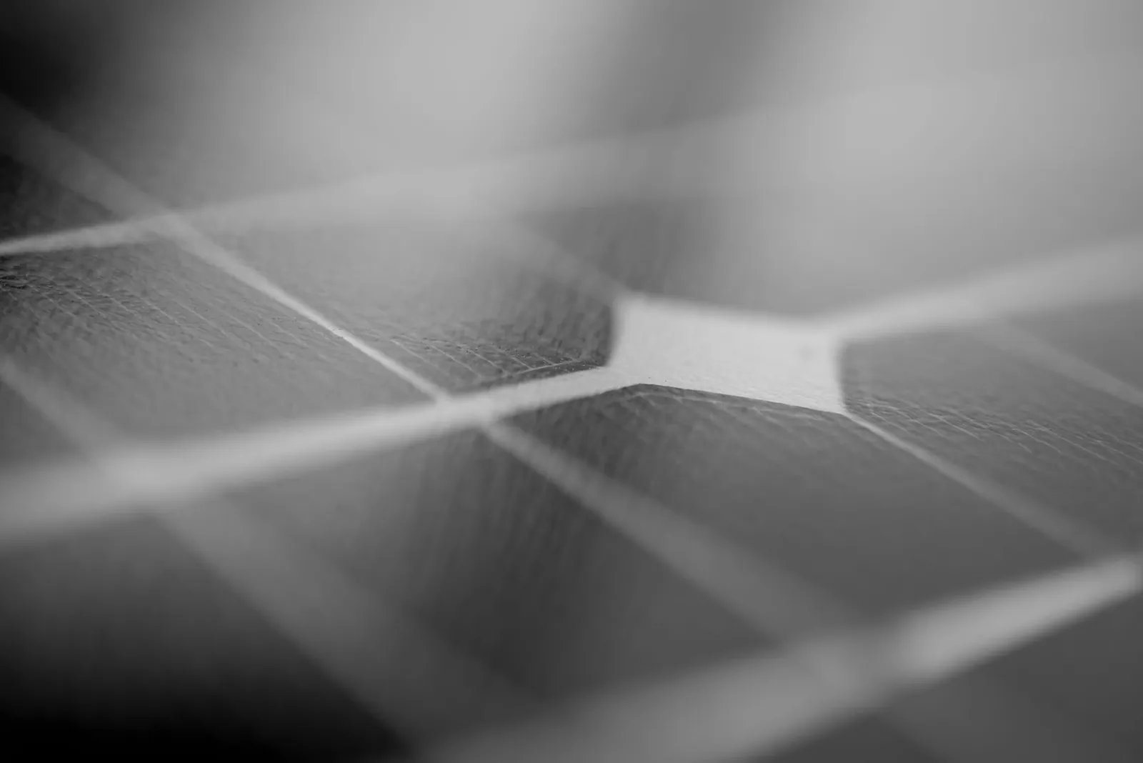 Detailed monochrome close-up of a solar panel surface showing texture and grid pattern. Stock photo illustrating Websol Energy System's expansion story.