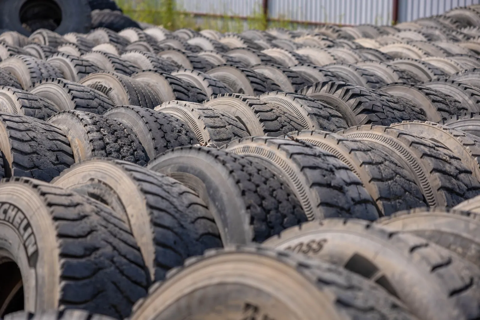 A large outdoor storage yard filled with rows of old tires, ideal for concepts like recycling or industrial use. Stock photo illustrating Tinna Rubber and Infrastructure's earning call story.