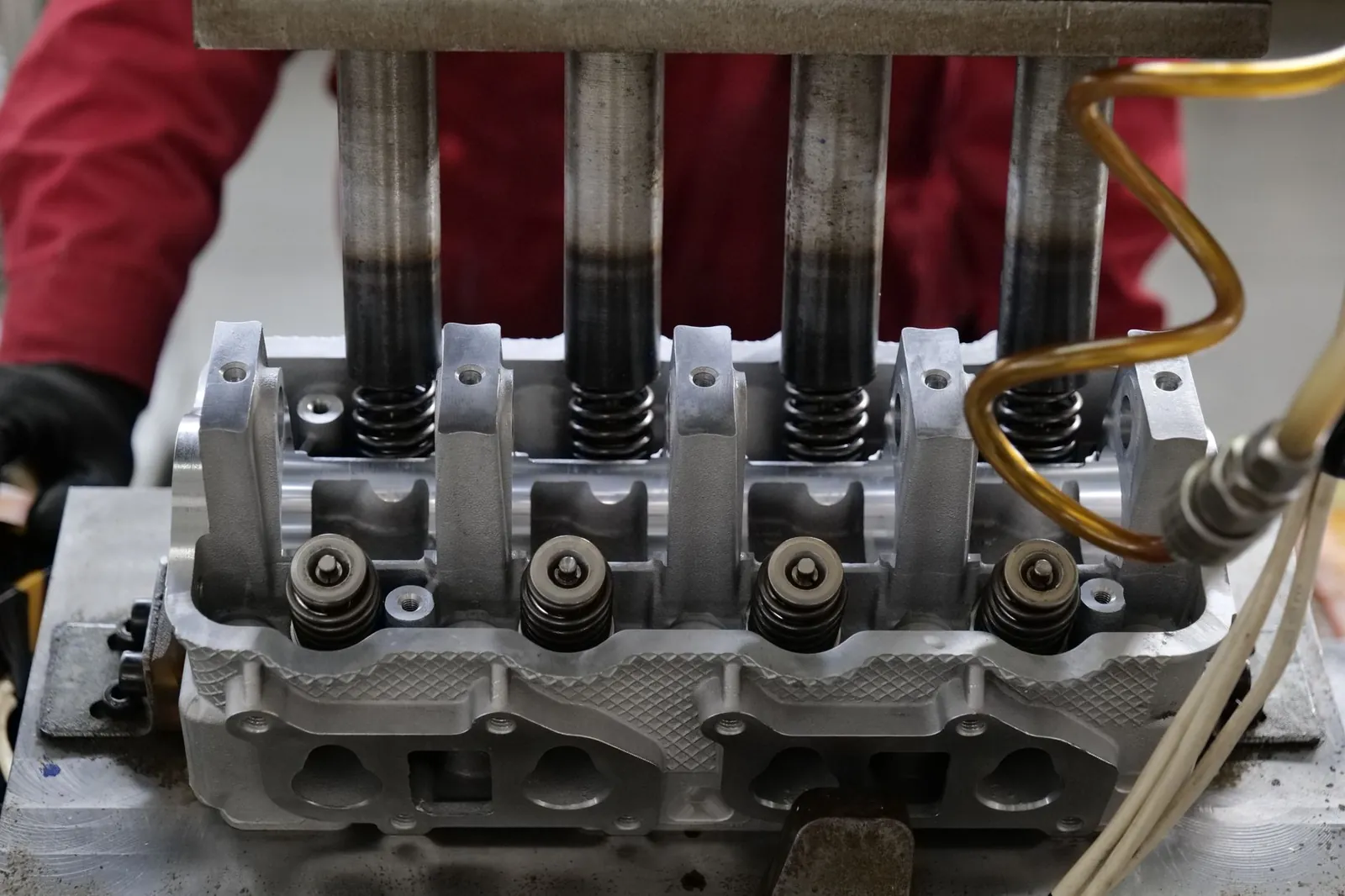 Detailed view of a metallic engine cylinder head with springs and pistons, assembled in an industrial workshop. Stock photo illustrating SPR Auto Technologies' fund raise story.