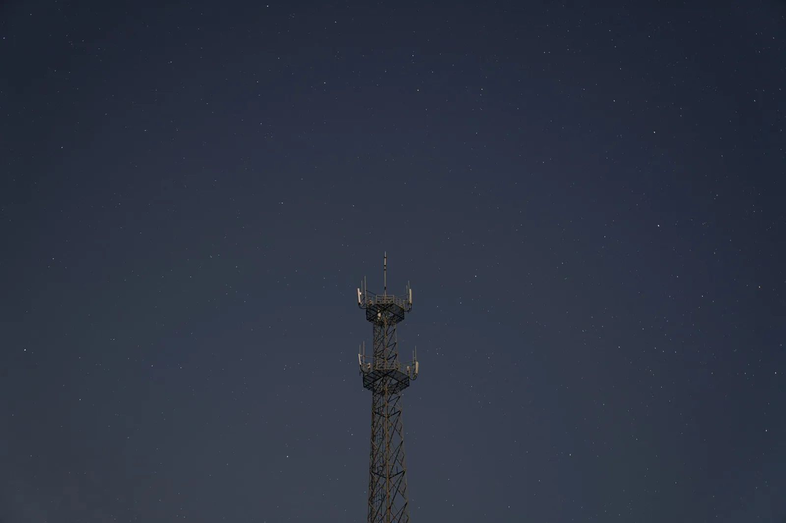 A transmission tower silhouetted against a starry night sky, showcasing technology and nature. Stock photo illustrating KP Green Engineering's new order story.