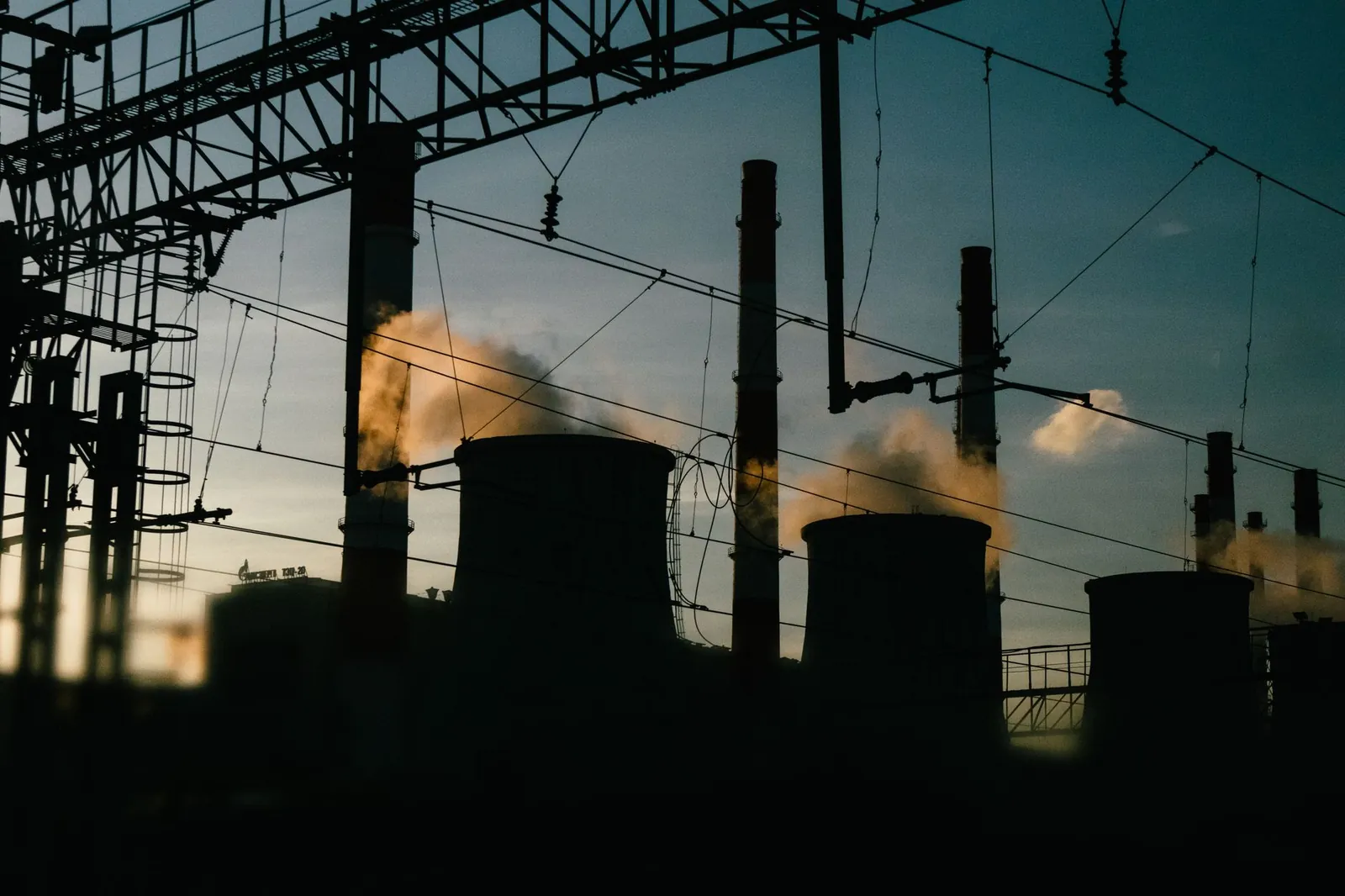 A silhouette of an industrial power plant with smokestacks emitting smoke at dusk. Stock photo illustrating Bluspring Enterprises' new order story.