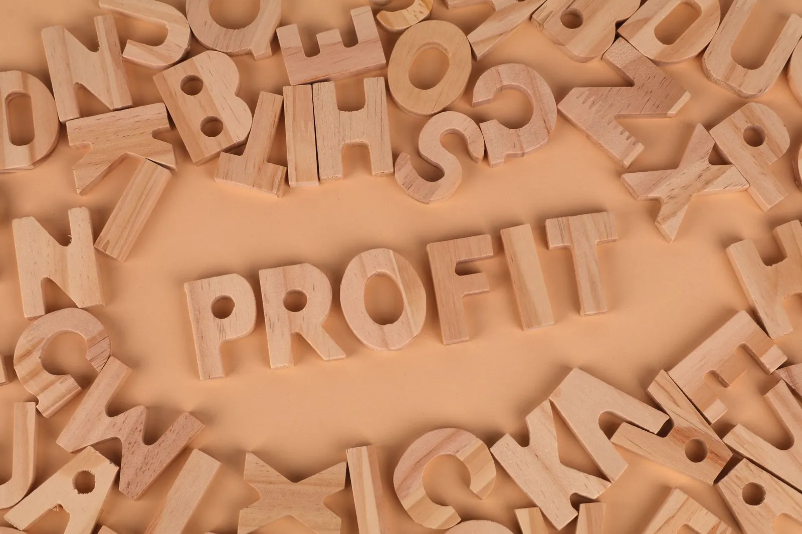 Wooden letters scattered on a table with 'PROFIT' prominently displayed. Stock photo for the ALFA News guide: Profit Warning Disclosures in India: A Guide to SEBI Rules.