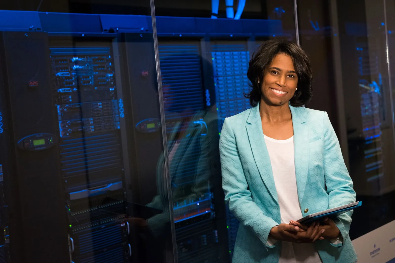 Smiling woman in data center showcasing technology expertise. Stock photo illustrating LTM's product launched story.