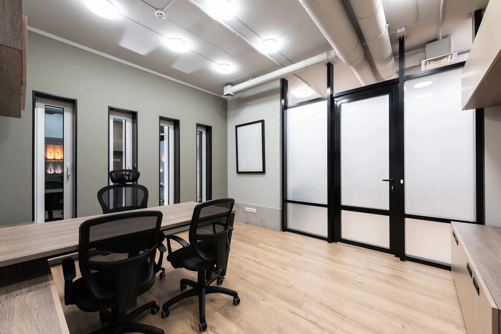 Wooden table and black office chairs placed in spacious room in new contemporary workplace. Stock photo illustrating Gretex Corporate Services' expansion story.