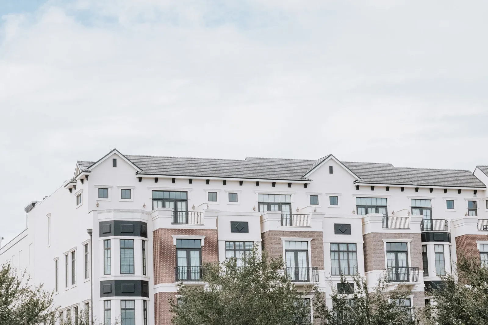 A stylish, multi-story luxury apartment building with a contemporary facade against a clear sky. Stock photo illustrating Prestige Estates Projects' product launched story.