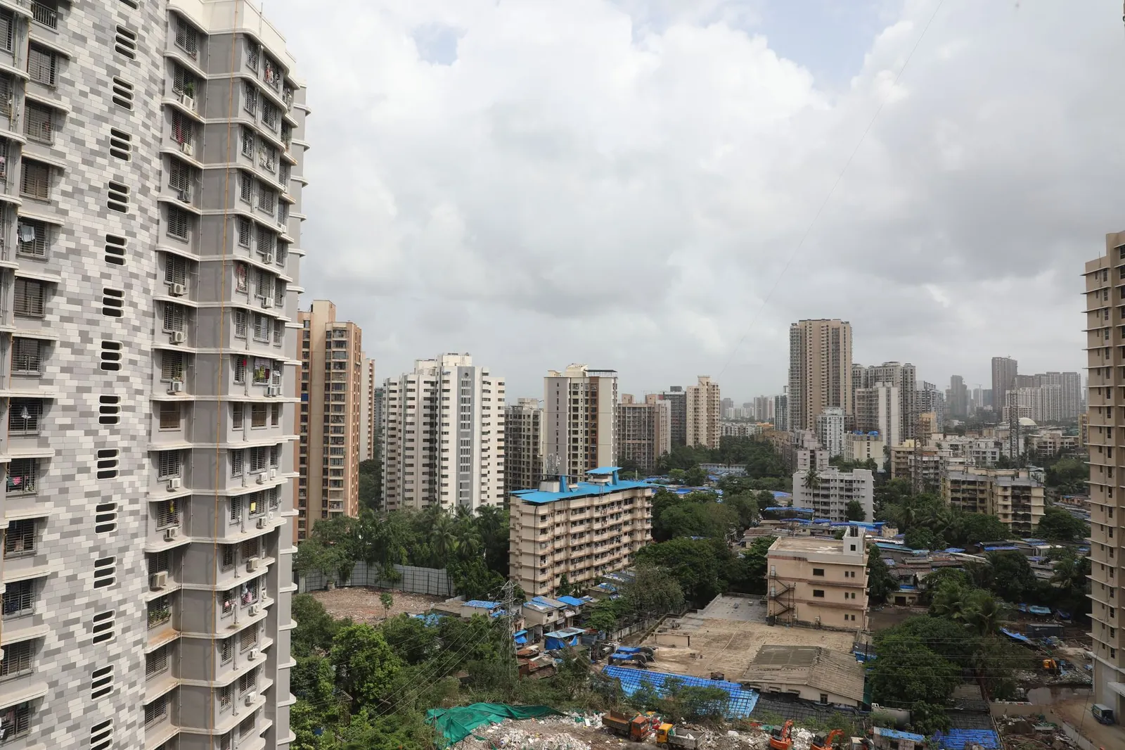 Aerial cityscape showcasing high-rise buildings and dense urban environment on a cloudy day. Stock photo illustrating Capacit'e Infraprojects' new order story.