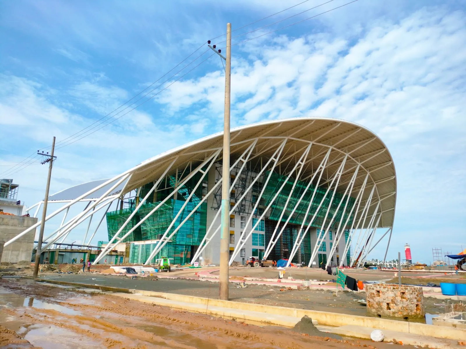 Contemporary architecture of a terminal under construction with a curved roof and glass facade. Stock photo illustrating GE Vernova T&D India's new order story.
