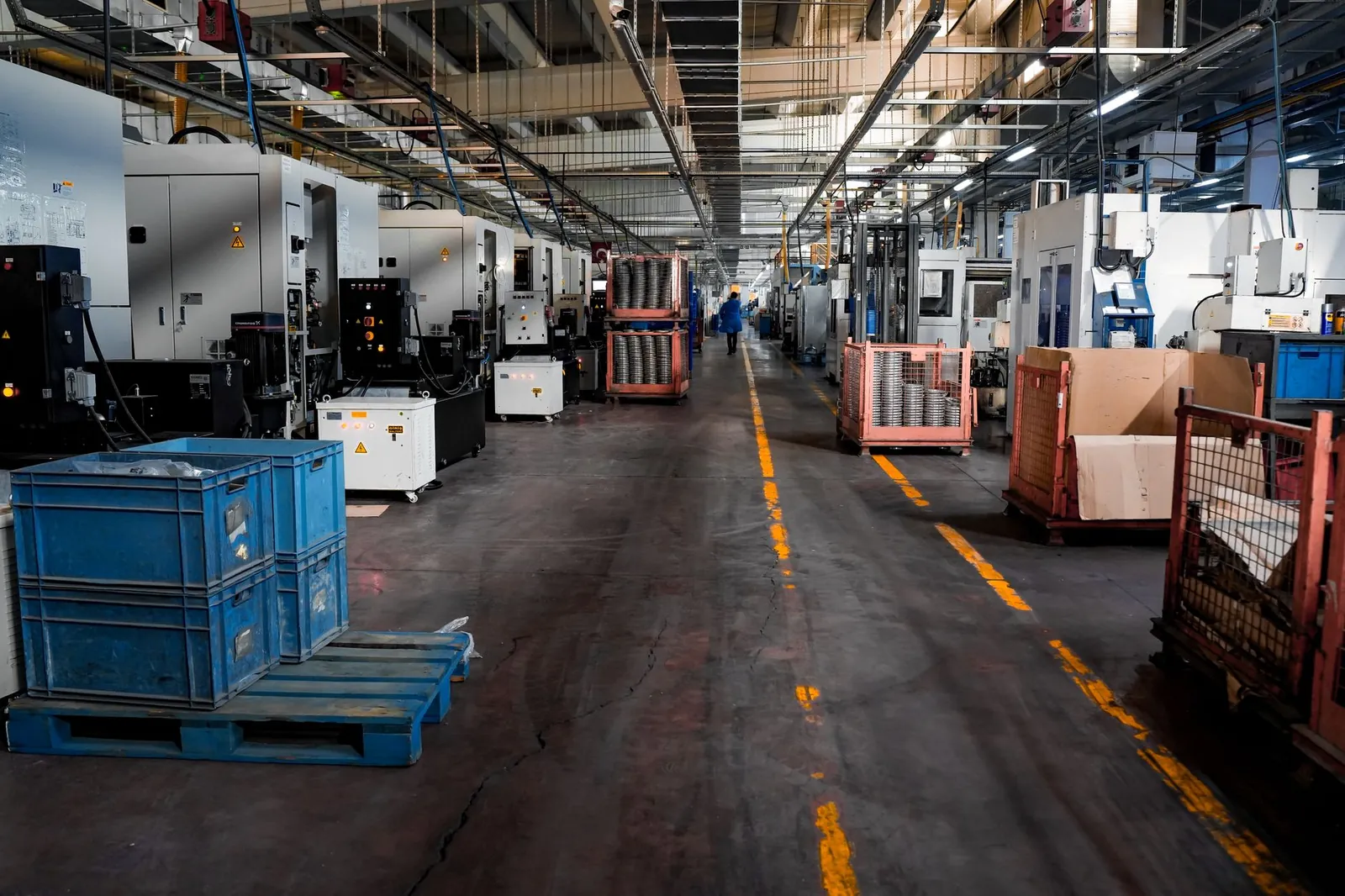 Vast industrial factory floor with machinery, crates, and structured workstations. Stock photo illustrating Exide Industries' partnership story.