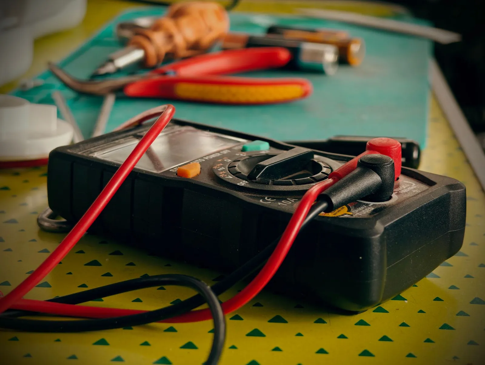 Close-up view of a multimeter and various tools on a workspace table. Stock photo illustrating Rishabh Instruments' earning call story.