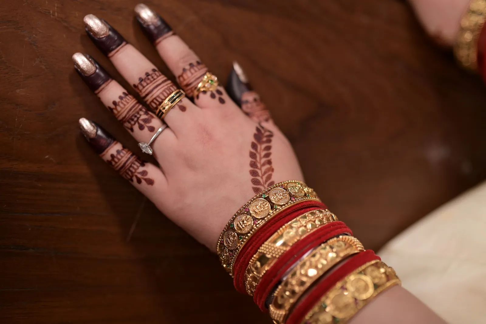 Hand adorned with intricate mehendi and gold jewelry showcasing traditional Indian culture. Stock photo illustrating Sky Gold and Diamonds' earning call story.