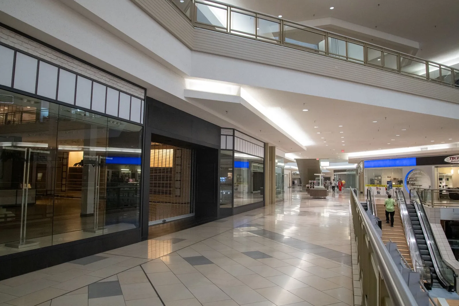 Spacious and contemporary mall interior with closed stores and escalator. Stock photo illustrating V2 Retail's earning call story.