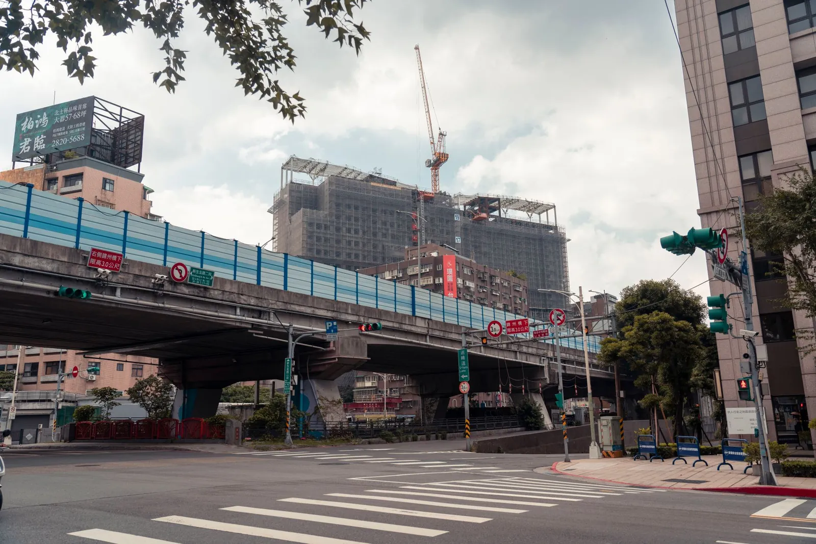 View of urban cityscape showing an overpass and construction site with a crane. Stock photo illustrating Ceigall India's earning call story.