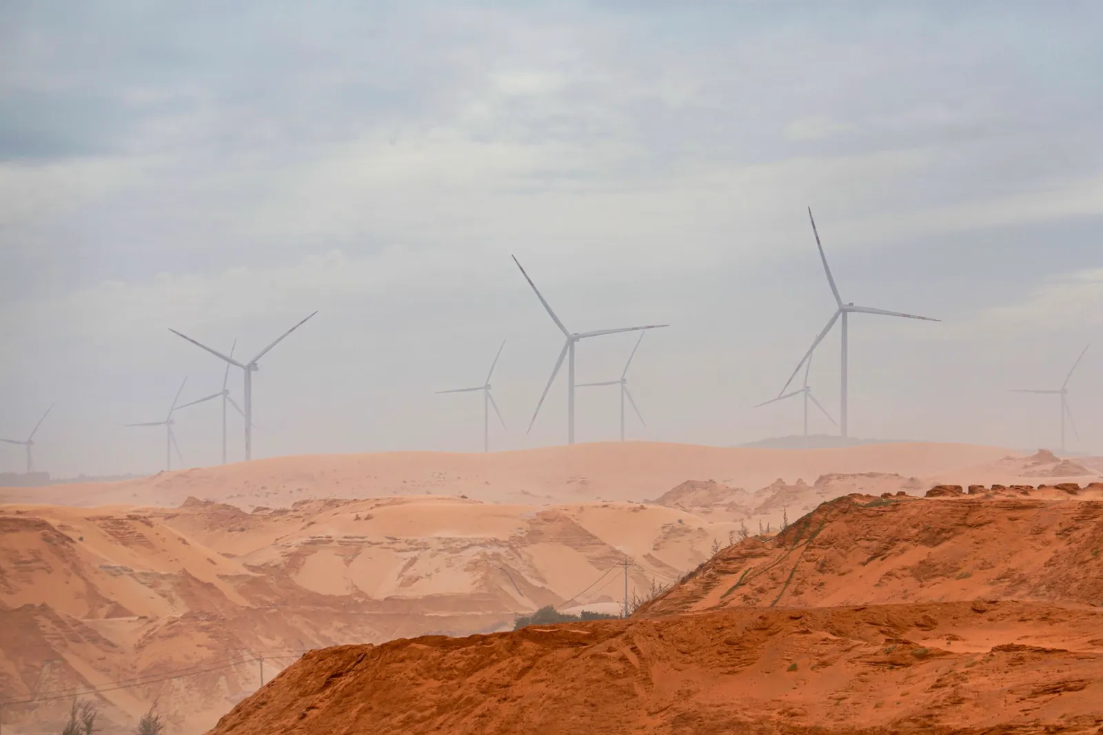 Wind turbines standing tall in the Bình Thuận desert, showcasing renewable energy. Stock photo illustrating Inox Wind's earning call story.