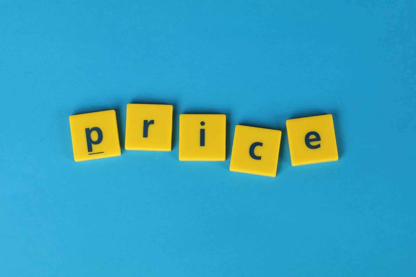 Yellow letter tiles spell the word 'price' against a vibrant blue backdrop, ideal for business concepts. Stock photo for the ALFA News guide: Unpublished Price Sensitive Information (UPSI): SEBI Rules Explained.