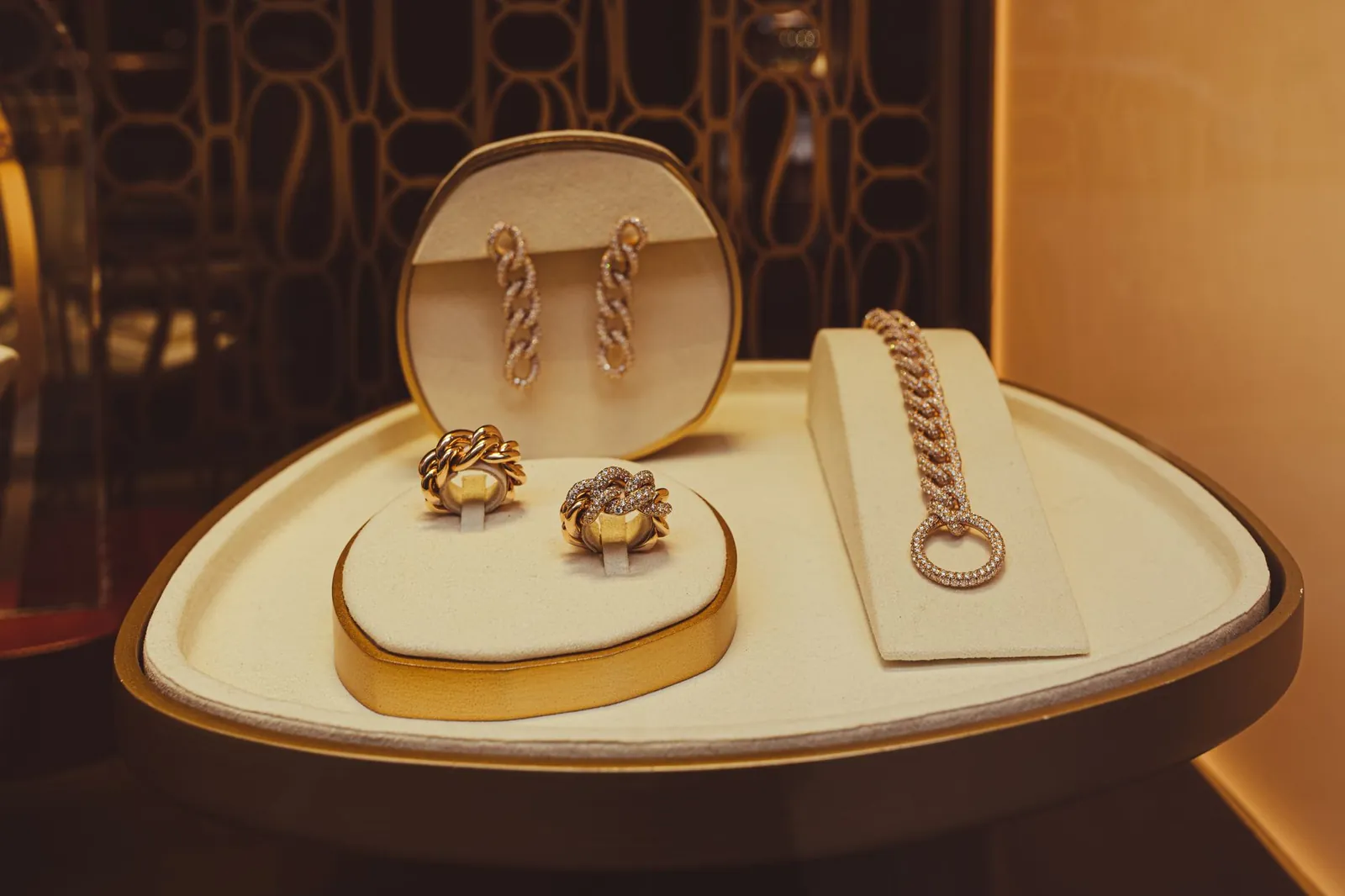 A refined display of elegant gold jewelry pieces in a store setting, showcasing earrings, rings, and a bracelet. Stock photo illustrating Senco Gold's partnership story.