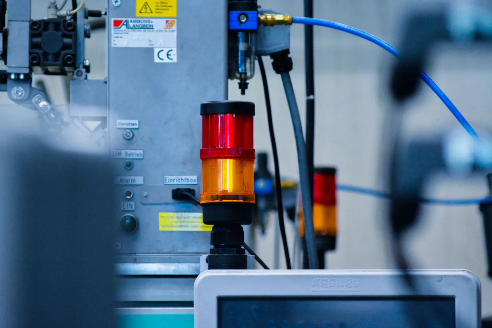 Detailed view of automated machinery with warning signals in an industrial setting. Stock photo illustrating Syrma SGS Technology's earning call story.