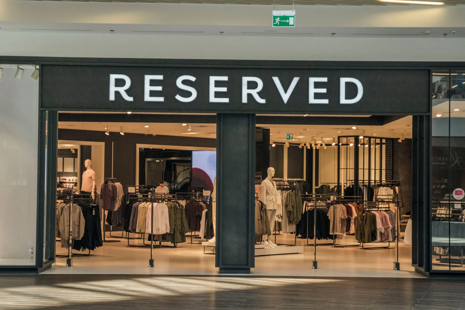 Chic clothing store entrance in a bustling shopping mall, showcasing trendy apparel. Stock photo illustrating S D Retail's expansion story.