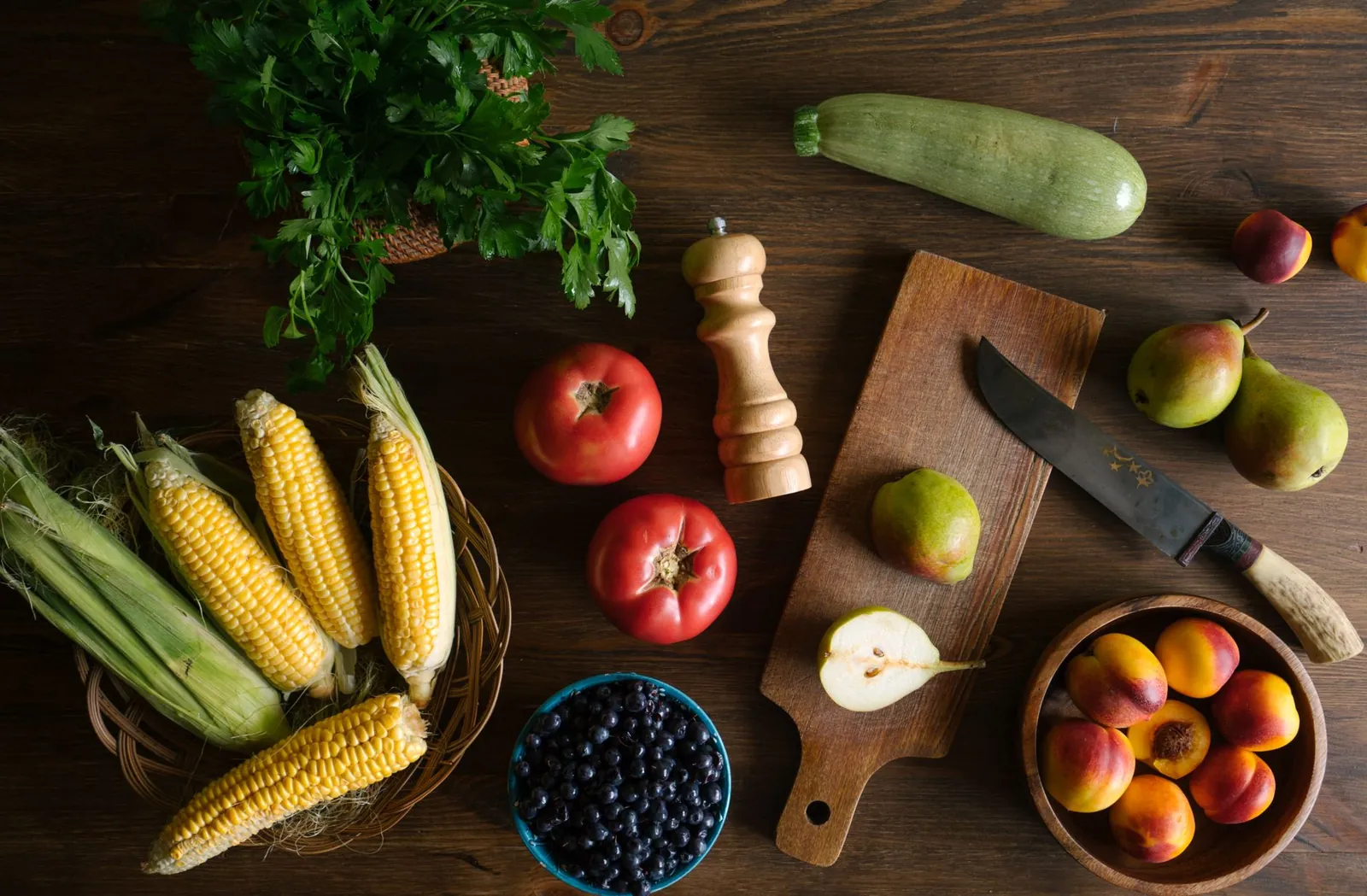 Top view of fresh fruits and vegetables including corn, pears, and tomatoes on a kitchen counter. Stock photo illustrating Gujarat Ambuja Exports' expansion story.
