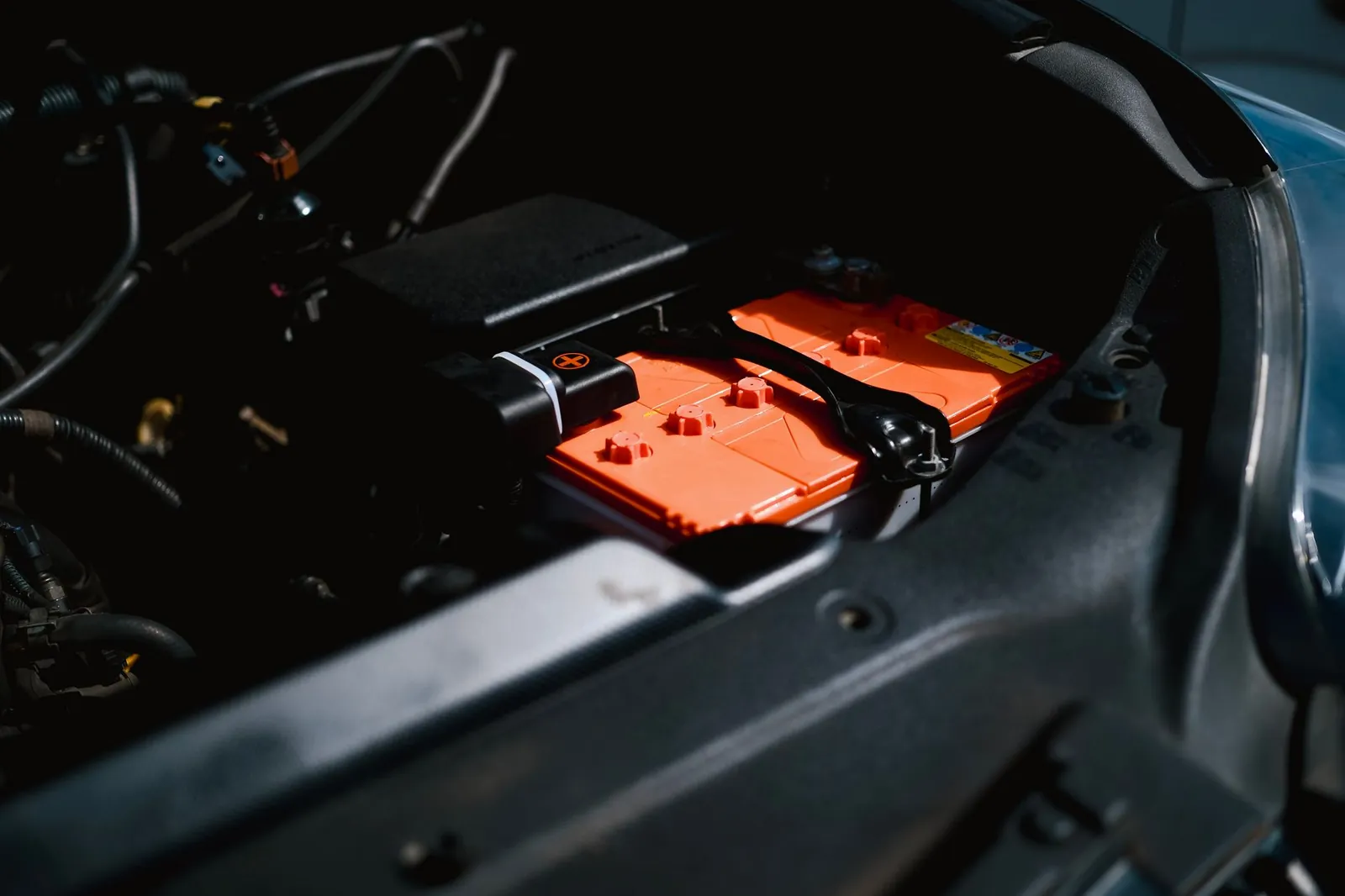 Detailed view of an electric car battery inside a vehicle's engine compartment, highlighting sustainable technology. Stock photo illustrating Neogen Chemicals' fund raise story.
