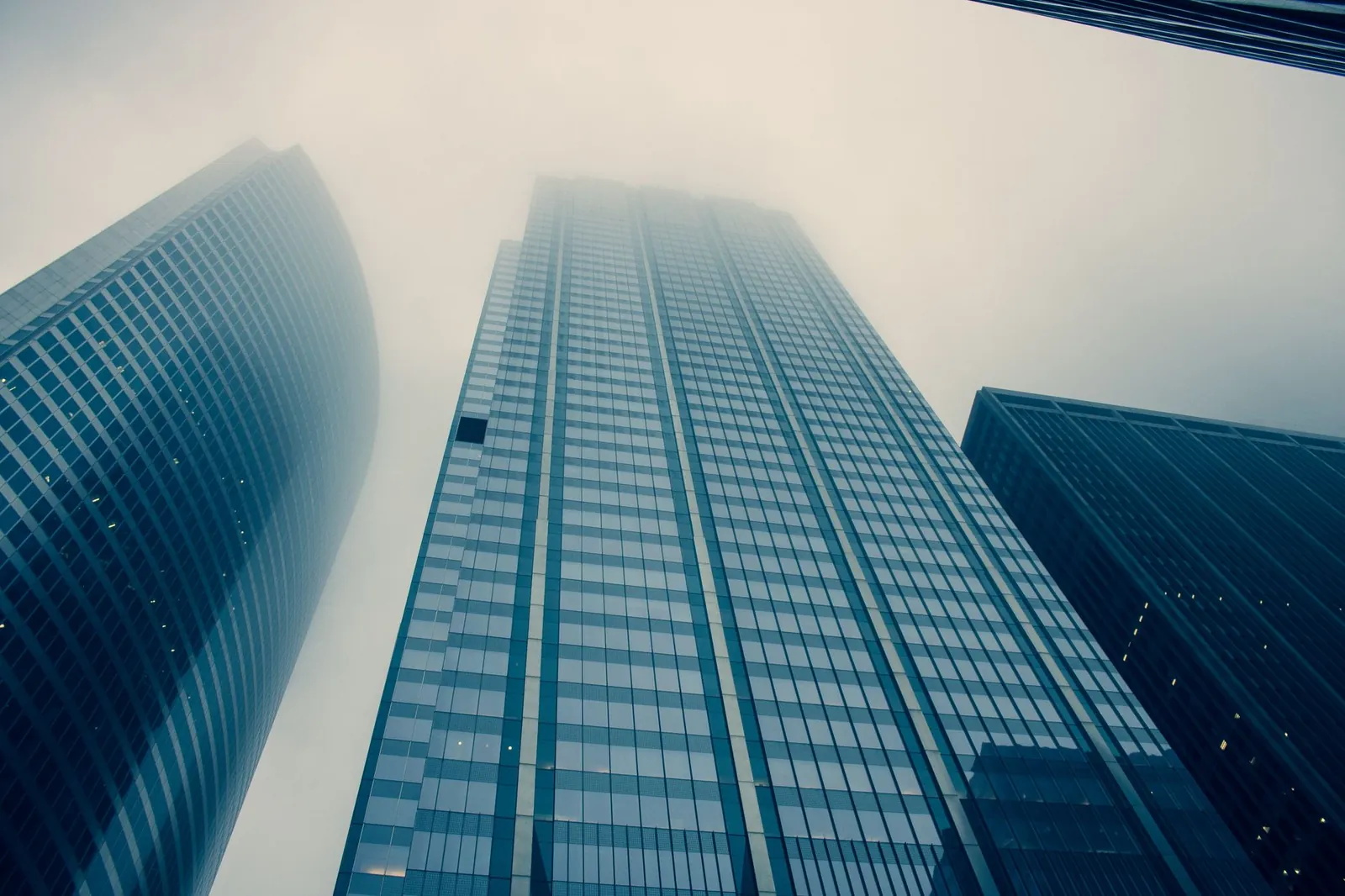 Captivating view of modern skyscrapers reaching into foggy skies, symbolizing urban growth. Stock photo illustrating Bajaj Finance's fund raise story.