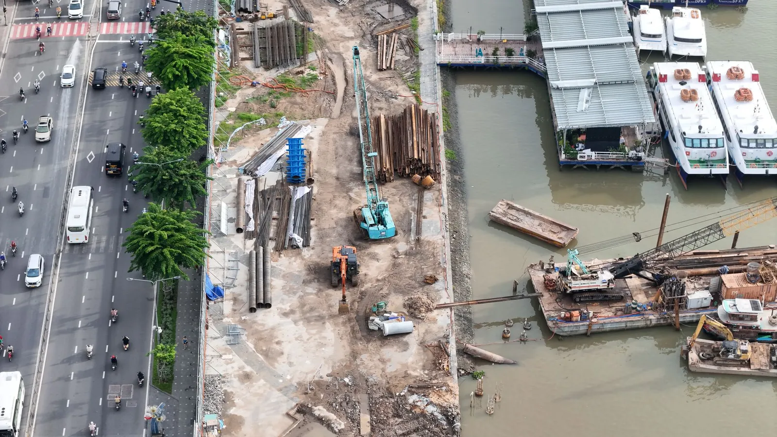 Aerial shot of a construction site by a river with adjacent road traffic and docked boats. Stock photo illustrating G R Infraprojects' new order story.