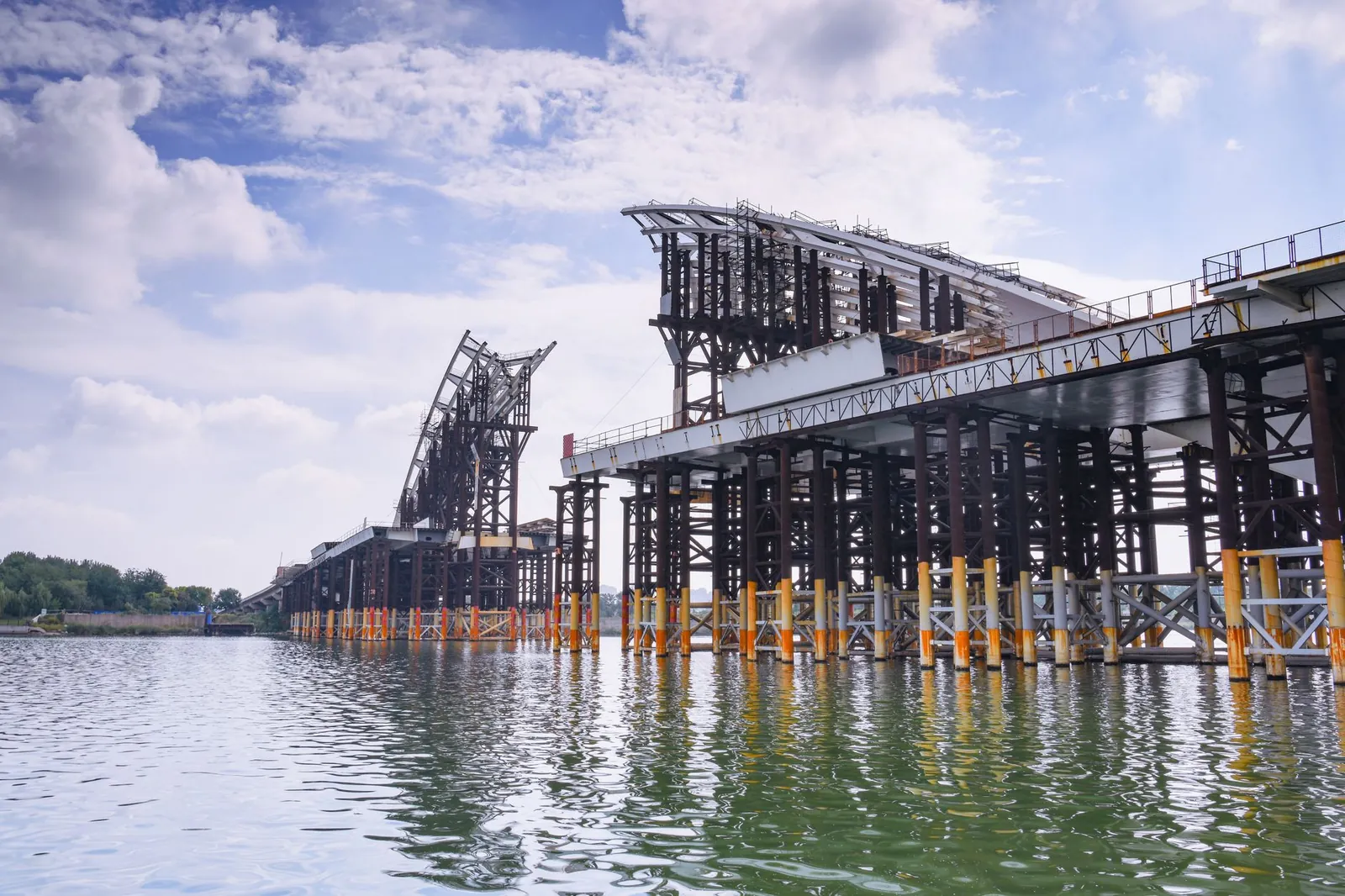 Steel framework of a large bridge under construction across a river on a sunny day. Stock photo illustrating SEPC's new order story.